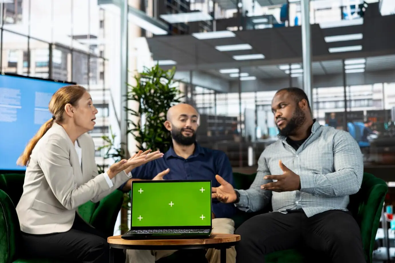 Freigestellter Tablet-Bildschirm neben Mitarbeitenden, die Forschungsunterlagen durchsehen.