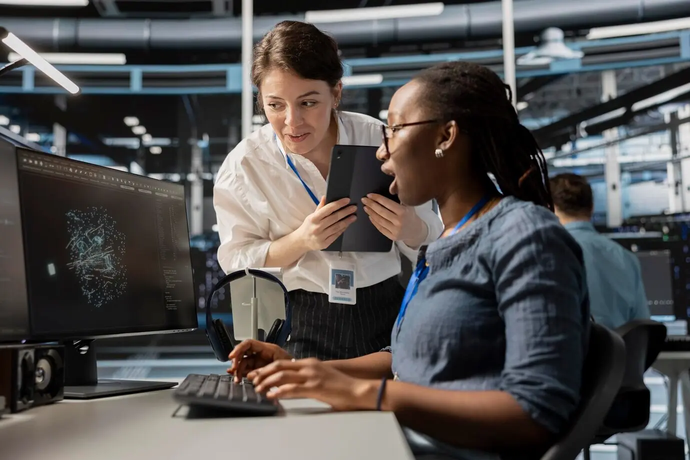 Rechenzentrumstechniker betrachten eine Visualisierung auf einem PC-Bildschirm.